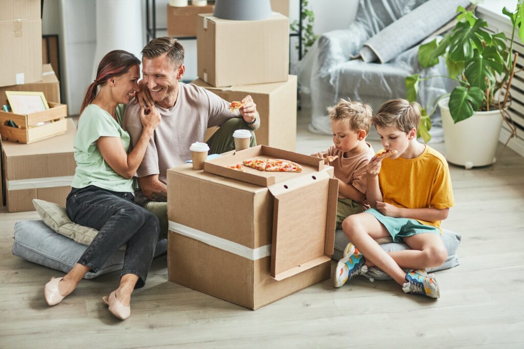 Happy Family Eating Pizza in New Home